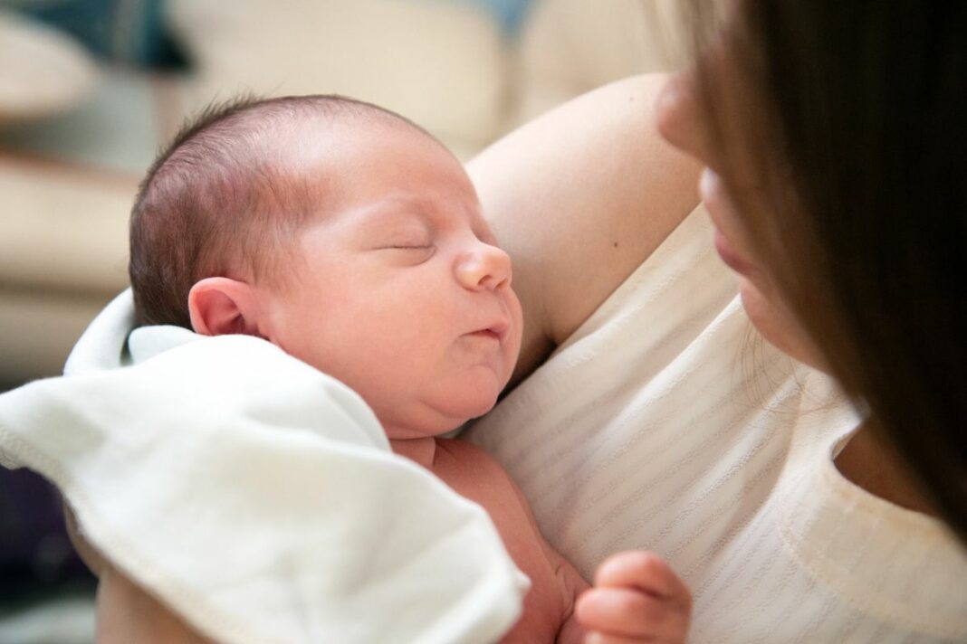 bebé recém-nascido a dormir no colo da mãe